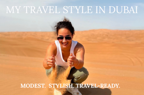 Woman joyfully jumping in the desert with blue sky background, wearing green joggers and white tank top, enjoying Dubai adventure